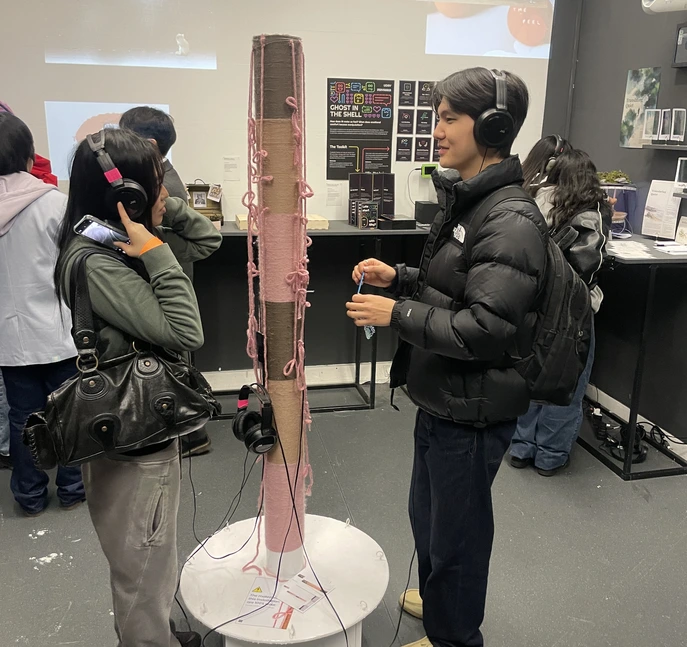 Exhibition — two visitors listening with headphones