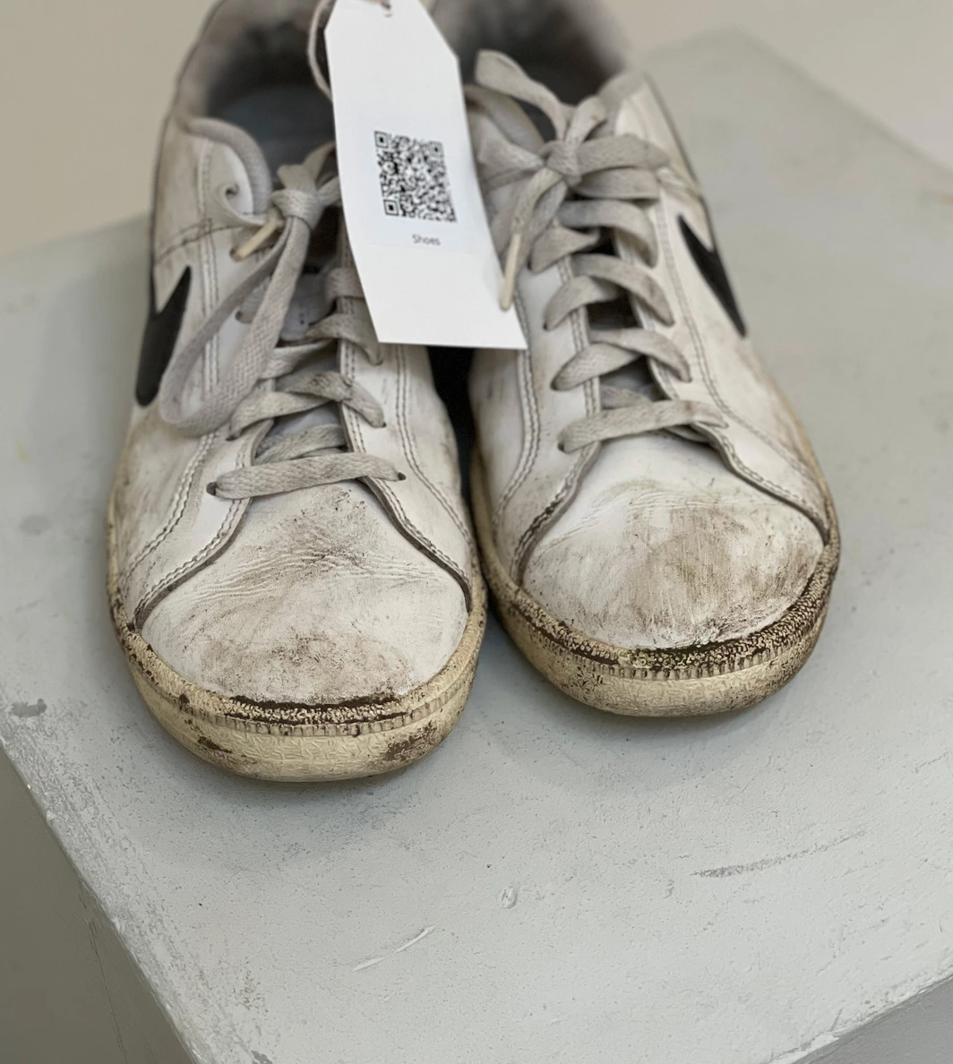 Exhibition — worn Nike shoes front view with QR tag