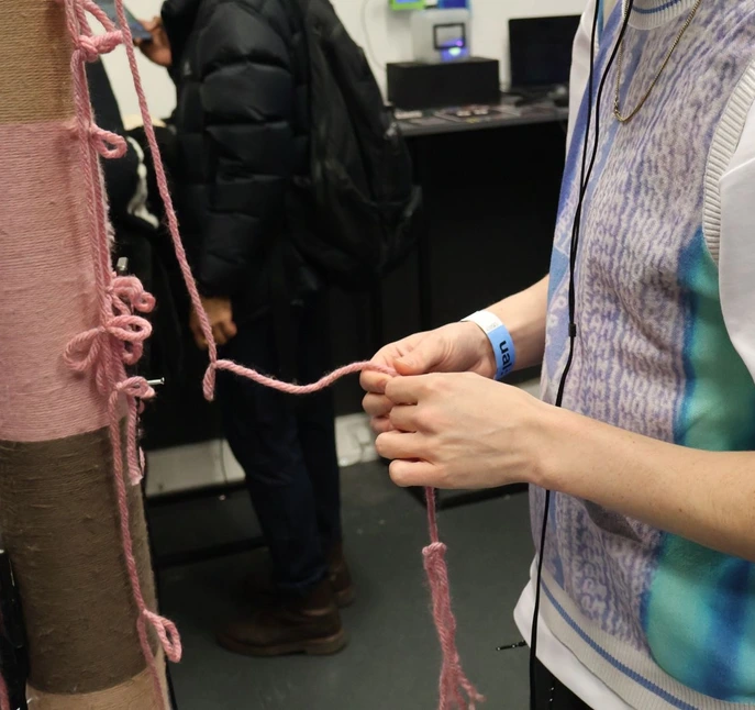Exhibition — close-up of hands tying knots